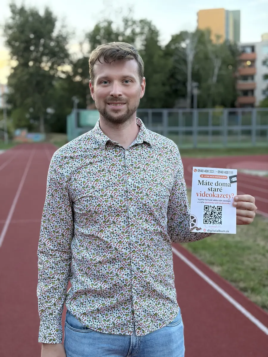 Člen tímu Digitalalbum s plagátom o digitalizácii videokaziet
